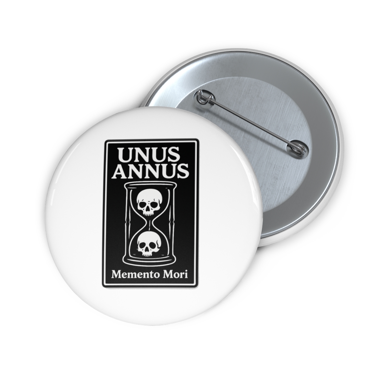 A black and white enamel pin featuring an hourglass with two skulls inside. The pin is on a brown card with the words "Unus Annus" and "Memento Mori" printed on it. - alternate angle 1, merchandise